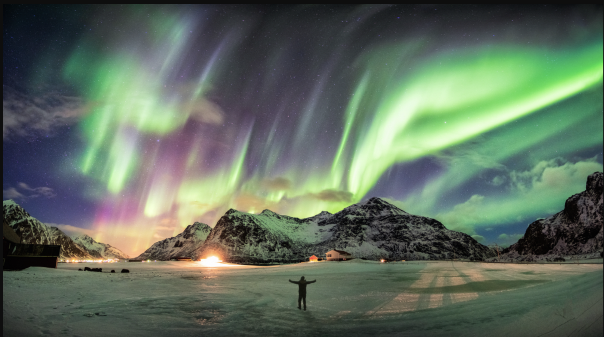 Flowing green waves of light criss-crossing the night sky from aurora borealis.