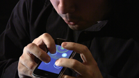 Ge plays Ocarina on an iPhone; holding and blowing into it