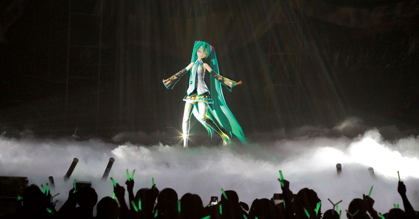 Hatsune Miku, a 3D animated Japanese singer with long green pigtails, on a foggy stage in front of many fans waving glow sticks